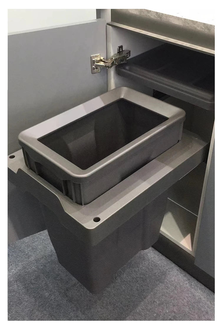 Gray storage bin attached to a cabinet inside a vehicle.