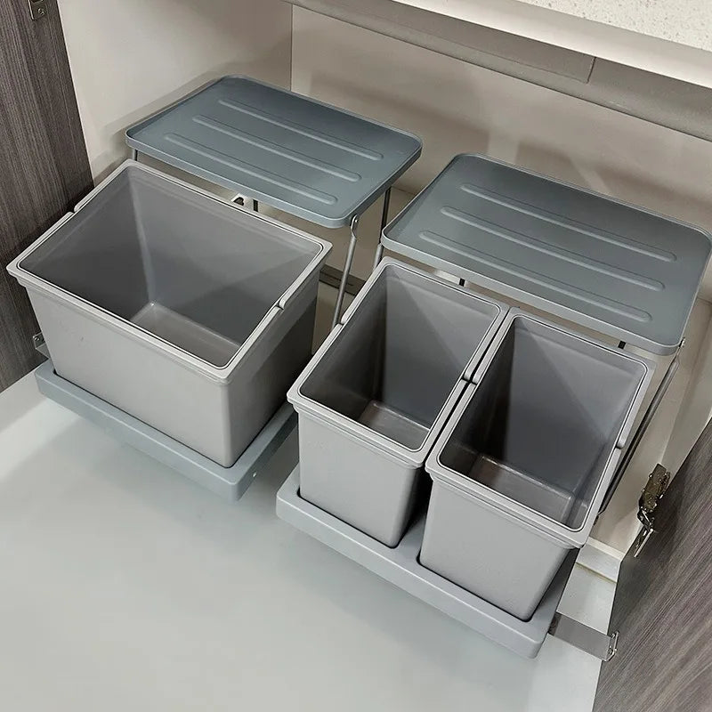 Set of grey trash bins with lids in a kitchen setting