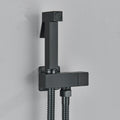Black shower head with flexible hose on a gray background