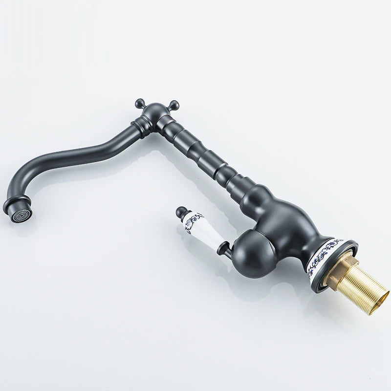 Black kitchen faucet with gold valve on a white background