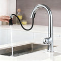 A modern chrome kitchen faucet with a curved high-arc spout and a black flexible pull-out sprayer, shown with a hand holding the sprayer and water flowing into a sink.