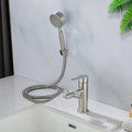 Stainless steel faucet with handheld shower head on a bathroom counter.