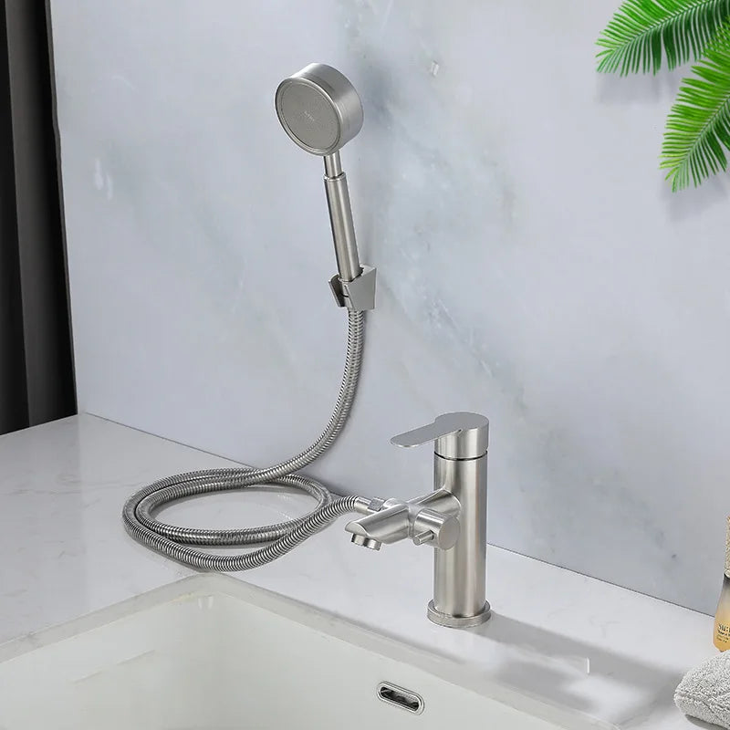 Stainless steel faucet with handheld shower head on a bathroom counter.