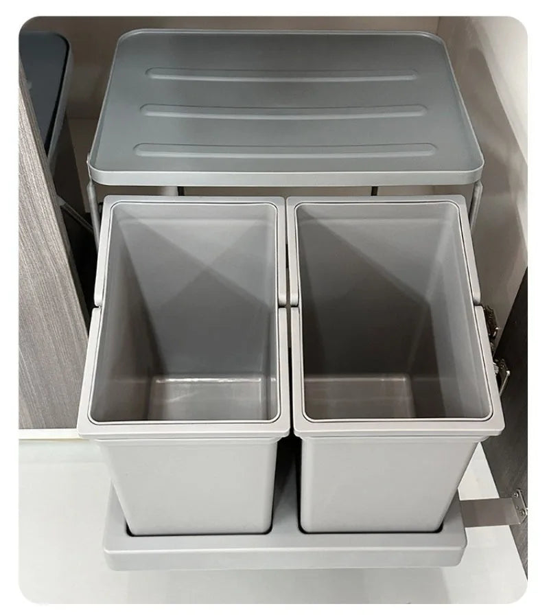 A two-compartment pull-out storage bin set with a gray lid and light gray plastic bins, shown installed in a cabinet interior.