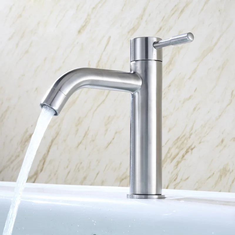 Chrome faucet with water flowing against a marble background