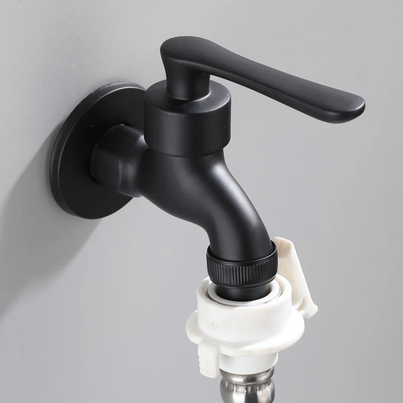 Black wall-mounted faucet with white valve on a gray background