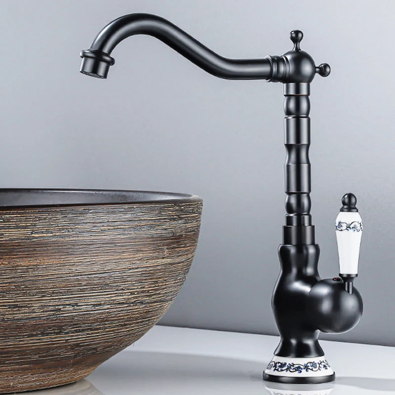 Black faucet with decorative spout next to a wooden sink basin on a gray background