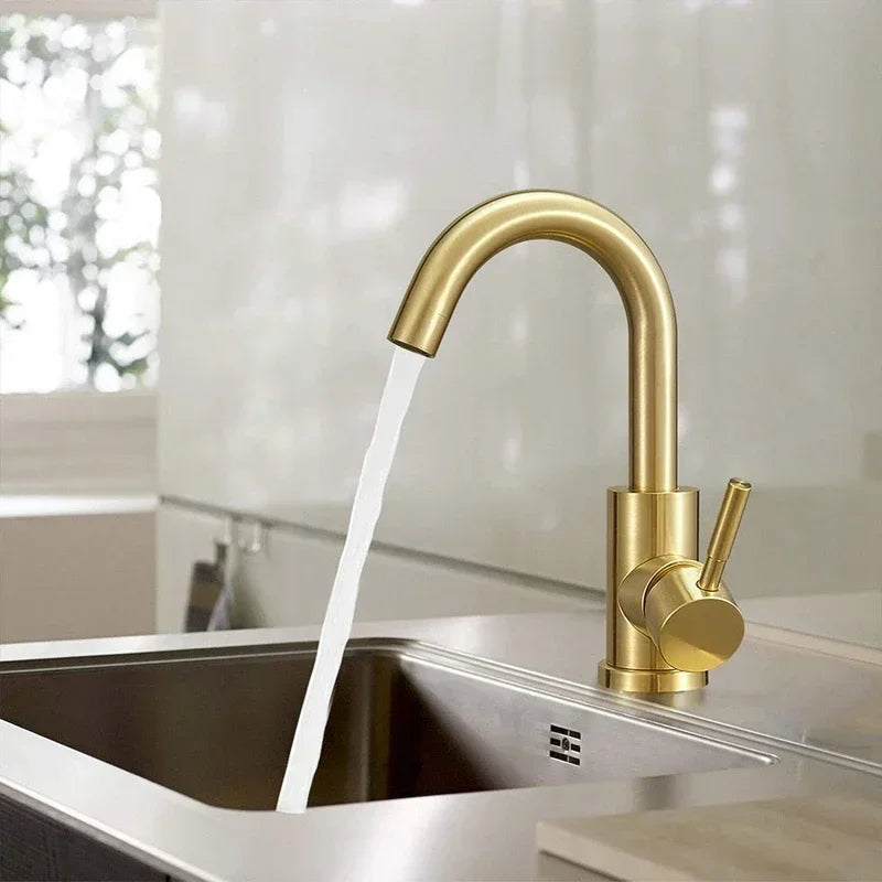 Gold kitchen faucet with water flowing into a sink