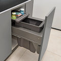 Grey kitchen cabinet with a pull-out trash bin containing cleaning supplies.