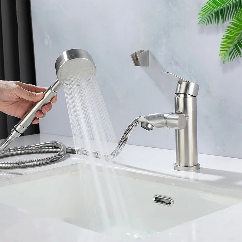 Handheld shower head being used with a sink and faucet in the background