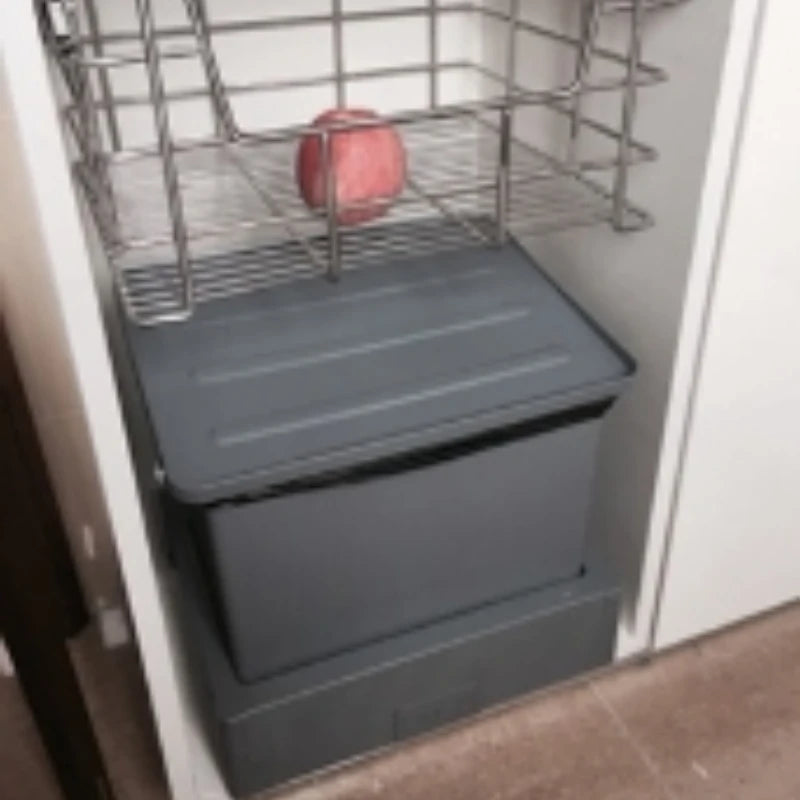 Gray storage bin with a metal wire basket on top in a kitchen setting.