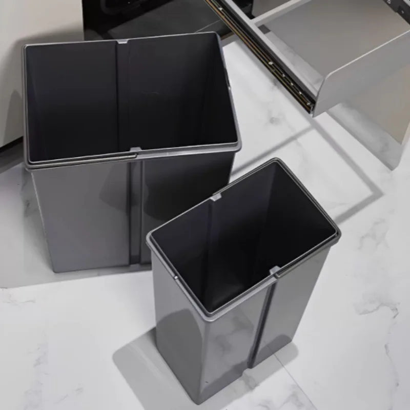Two gray trash bins on a marble surface