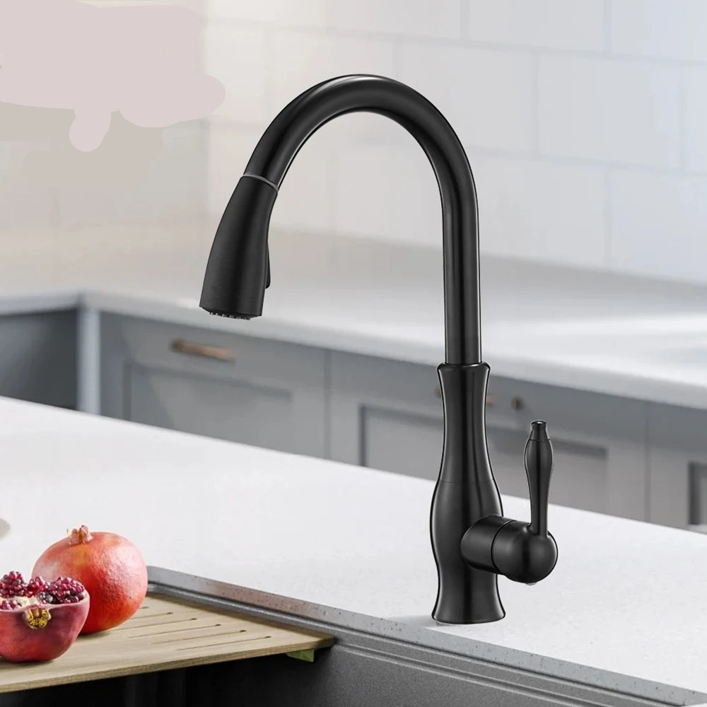 Black kitchen faucet on a kitchen counter with pomegranates and a cutting board.